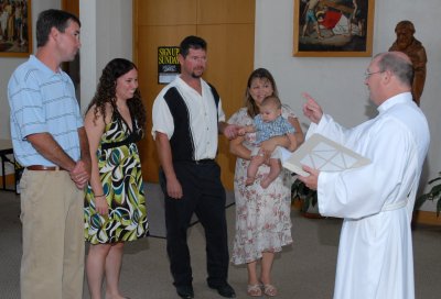 Deacon John speaking with parents and godparents.